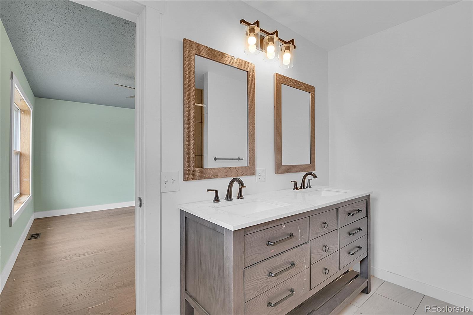 211 Chalet Drive Black Hawk, CO 80422 - Photo 13 of 36 a bathroom with a double vanity sink and a mirror