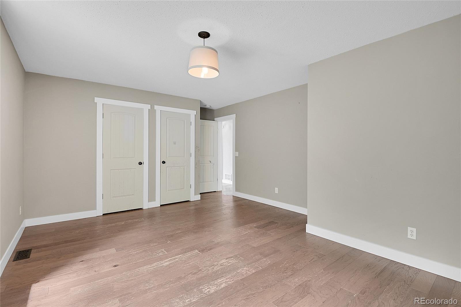 211 Chalet Drive Black Hawk, CO 80422 - Photo 15 of 36 a view of an empty room with wooden floor and windows