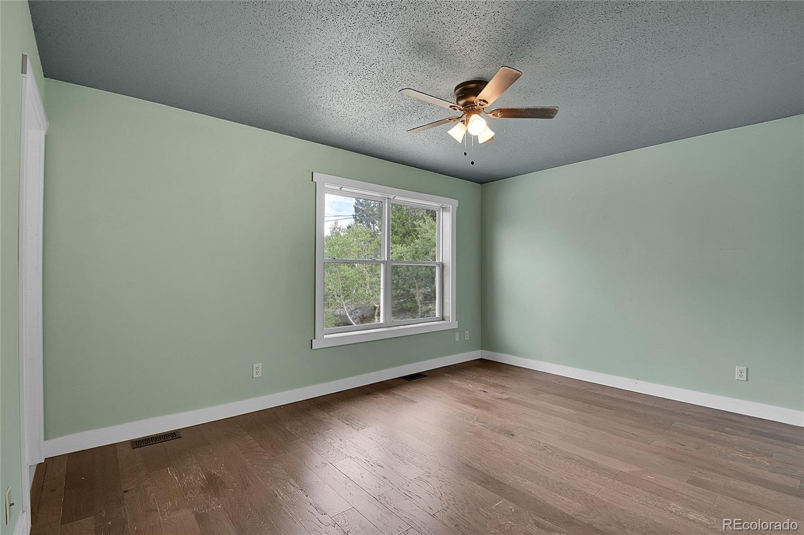 211 Chalet Drive Black Hawk, CO 80422 - Photo 10 of 36 a view of an empty room with wooden floor and a window