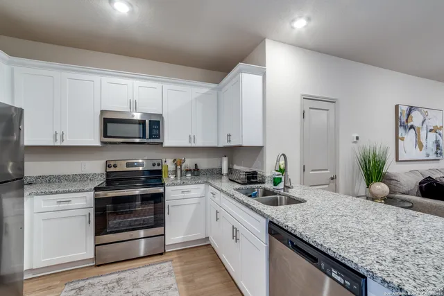 a kitchen with sink a microwave and cabinets