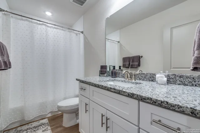 a bathroom with a granite countertop sink and a mirror