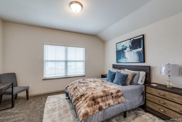 a bedroom with a bed lamp and a window