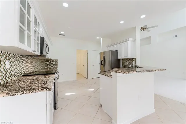 a kitchen with stainless steel appliances granite countertop a refrigerator and a stove