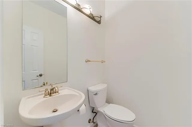 a bathroom with a sink a toilet and mirror