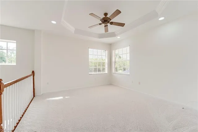 en empty room with windows and ceiling fan