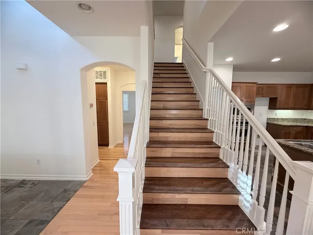 a view of staircase with wooden floor and a chandelier