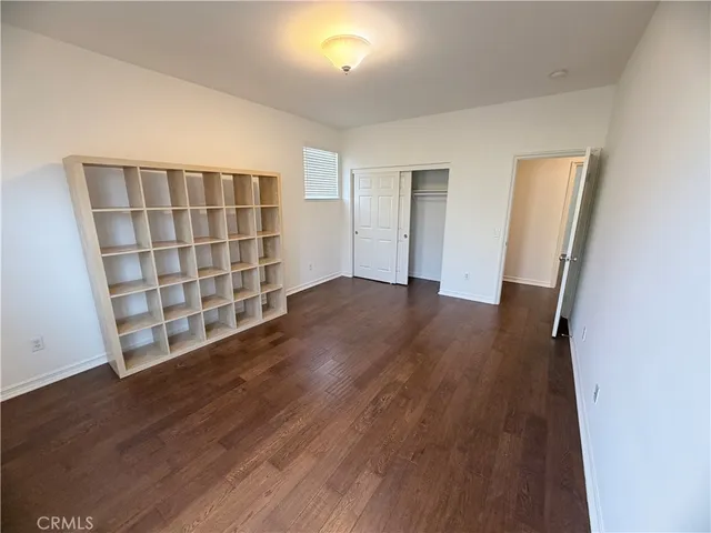 an empty room with wooden floor and closet