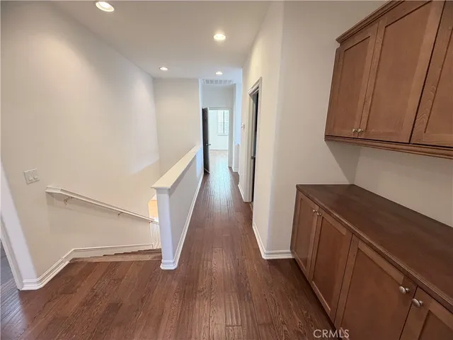 a view of hallway with stairs and wooden floor