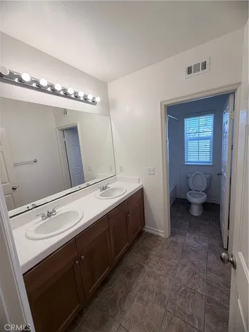 a spacious bathroom with a double vanity sink and a mirror