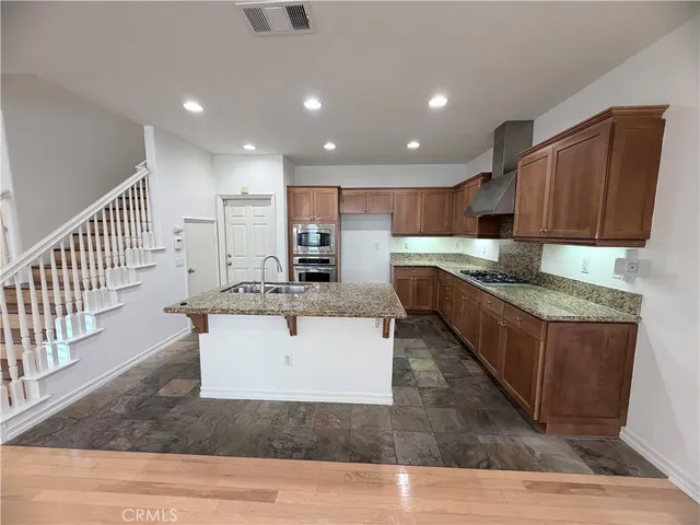 a kitchen with kitchen island granite countertop wooden cabinets a sink and dishwasher