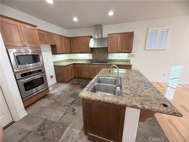 a kitchen with stainless steel appliances granite countertop a sink and a stove
