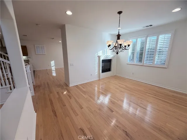 a view of a room with a kitchen space and wooden floor