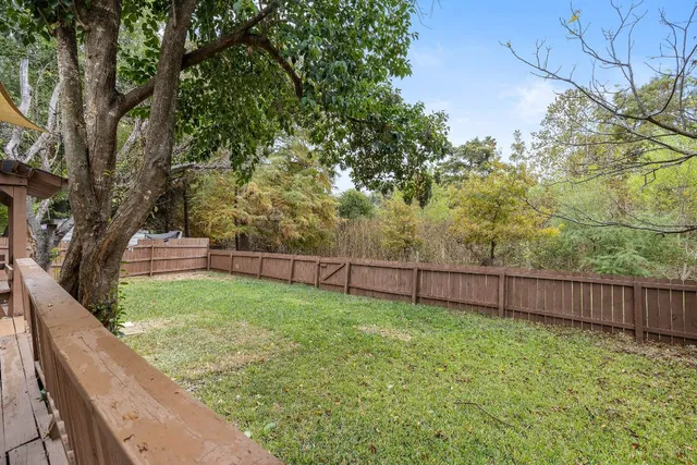 a view of a backyard with wooden fence