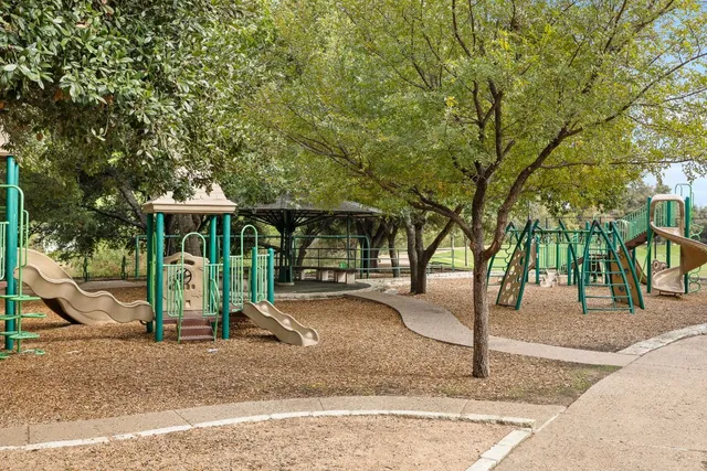 a view of a house with backyard and trees