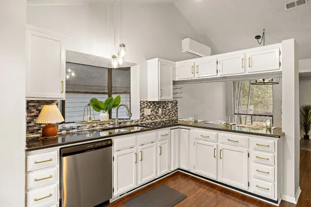 a kitchen with granite countertop white cabinets and white appliances