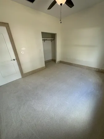 en empty room with chandelier fan