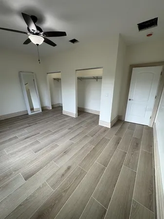 a view of empty room with wooden floor