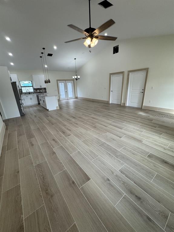 2383 Southwest 2nd Court Okeechobee, FL 34974 - Photo 42 of 48 a view of an empty room with kitchen and chandelier fan