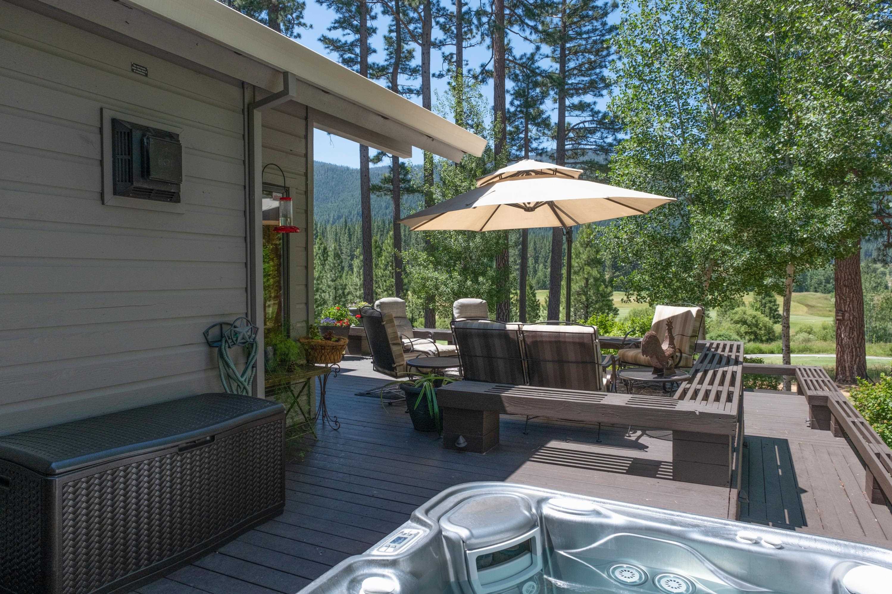 134 Quail View Circle Clio, CA 96106 - Photo 33 of 49 a view of a patio with couches table and chairs under an umbrella with a barbeque
