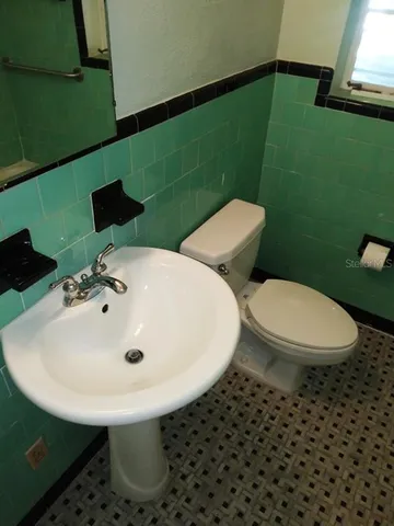 a bathroom with a toilet sink and mirror