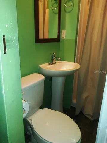a bathroom with a toilet sink and mirror