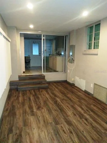a view of a room with wooden floor and a rug