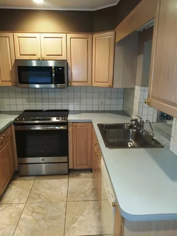 a kitchen with a sink a stove and cabinets