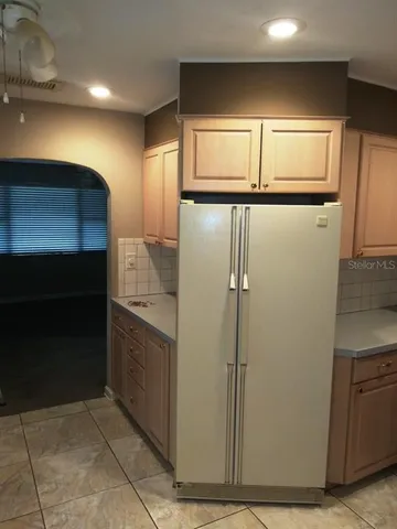 a view of a refrigerator in kitchen and a sink