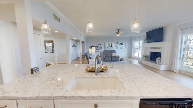 a kitchen with kitchen island a counter top space a sink stainless steel appliances and cabinets