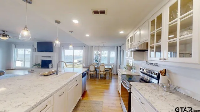 a large kitchen with stainless steel appliances granite countertop a lot of counter space and a sink