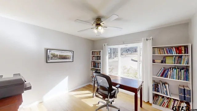 a view of a workspace with furniture and a book shelf