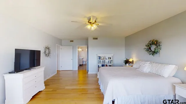a bedroom with a bed and a flat tv screen on dresser