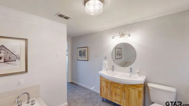 a bathroom with a sink mirror and vanity