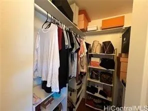 a view of walk in closet with clothes and shoes