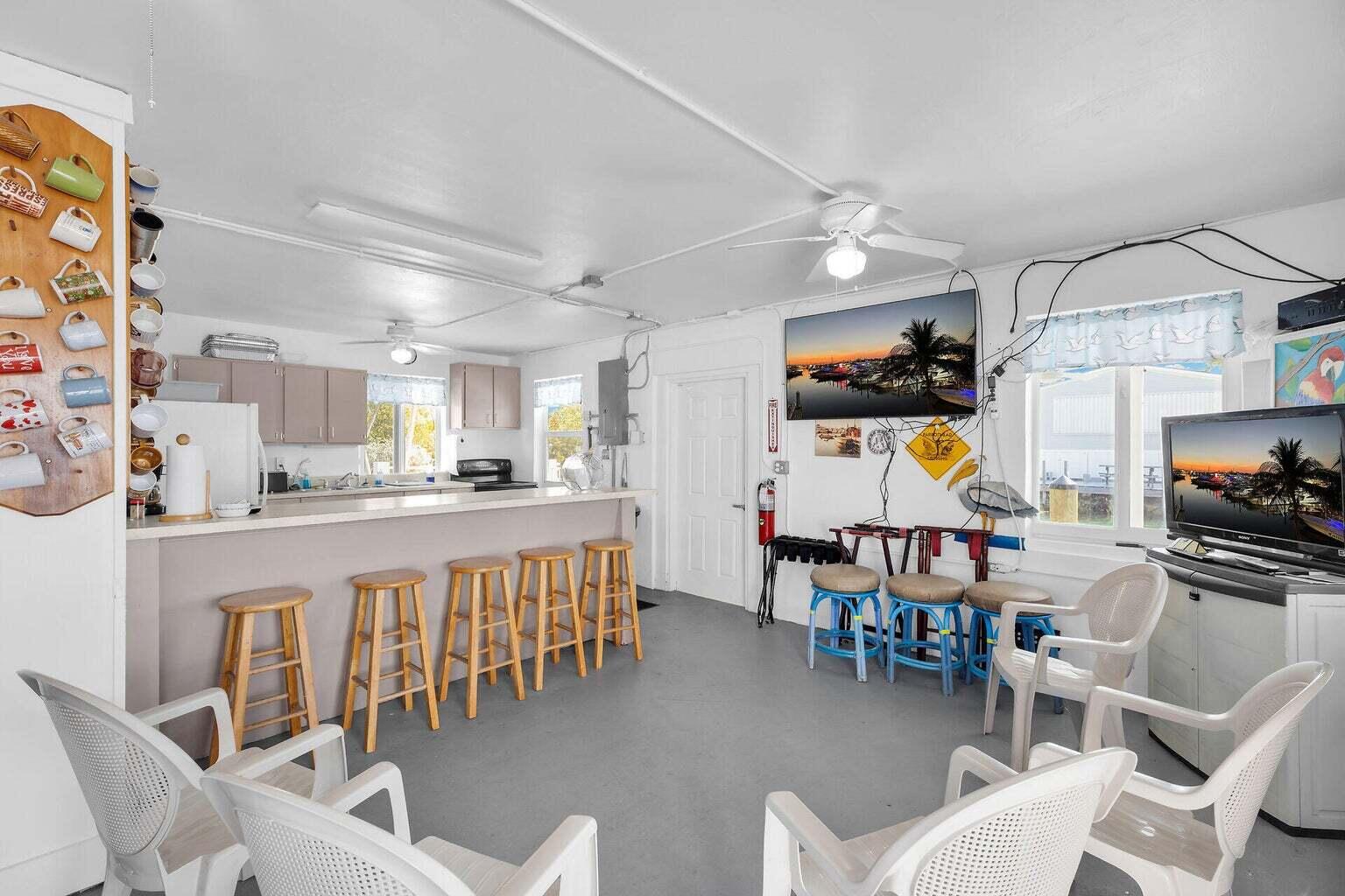 55 Boca Chica Road, Unit 85 Key West, FL 33040 - Photo 32 of 47 a large white kitchen with a table and chairs