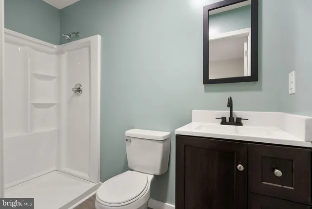 a bathroom with a toilet a sink a mirror and vanity