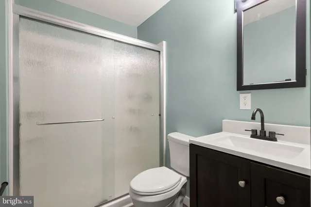 a bathroom with a sink a toilet a mirror and vanity