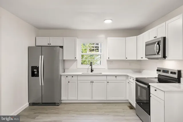 a kitchen with a white cabinets and refrigerator