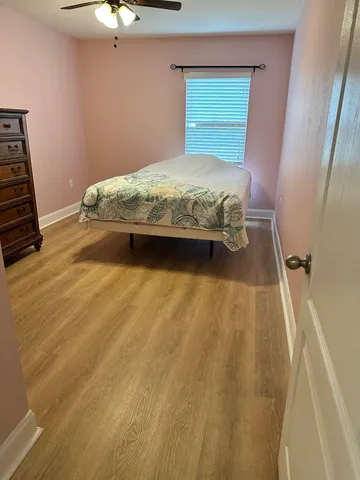 a view of a swimming pool with a table and chairs under palm trees