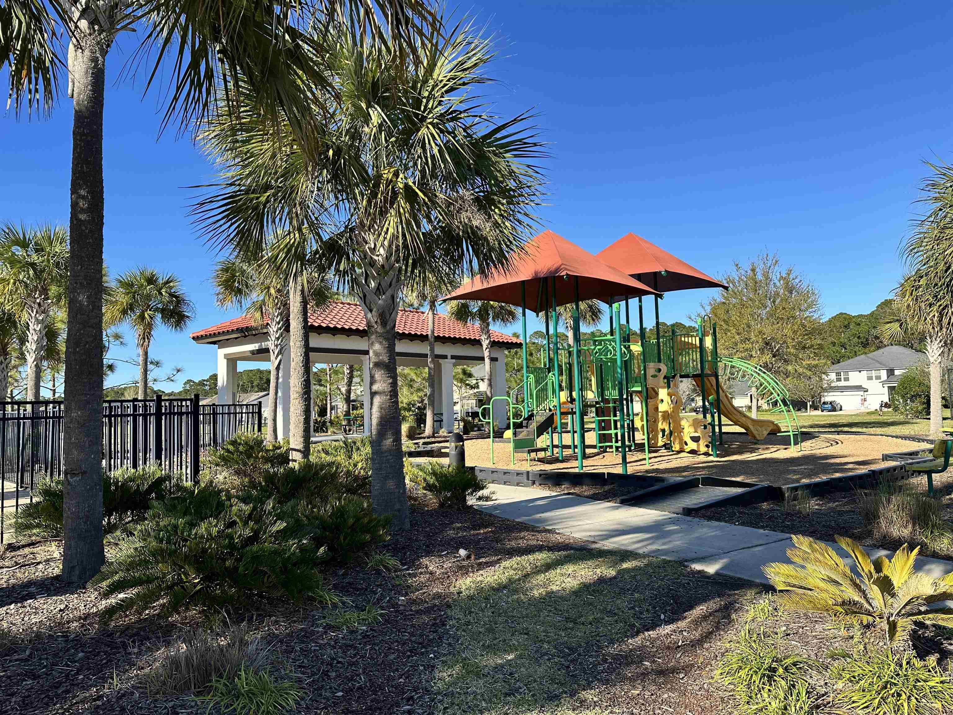 35 Root Lane St. Augustine, FL 32084 - Photo 14 of 16 a view of a swimming pool with a table and chairs under palm trees