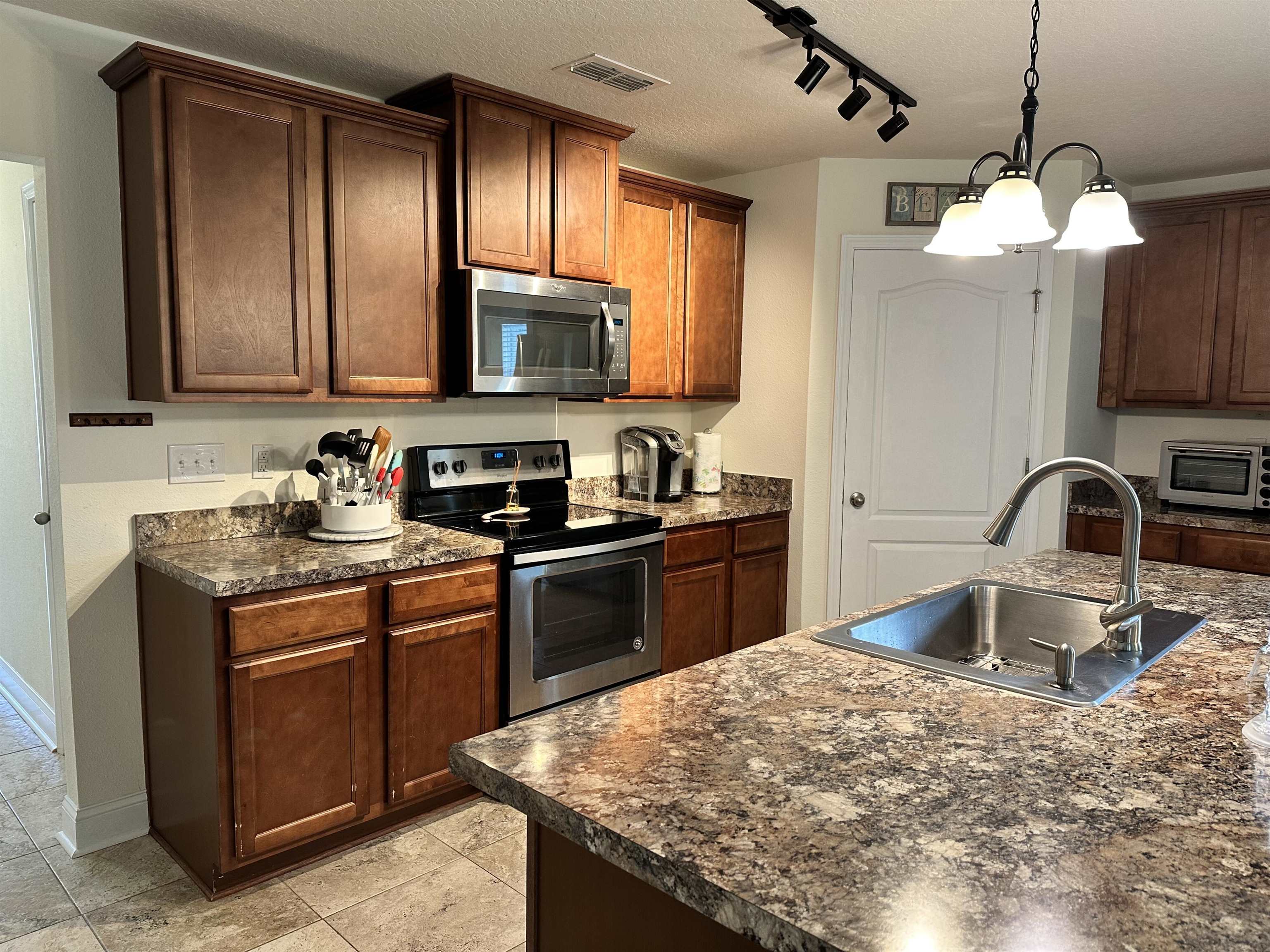 35 Root Lane St. Augustine, FL 32084 - Photo 2 of 16 a kitchen with kitchen island granite countertop a sink stainless steel appliances and cabinets