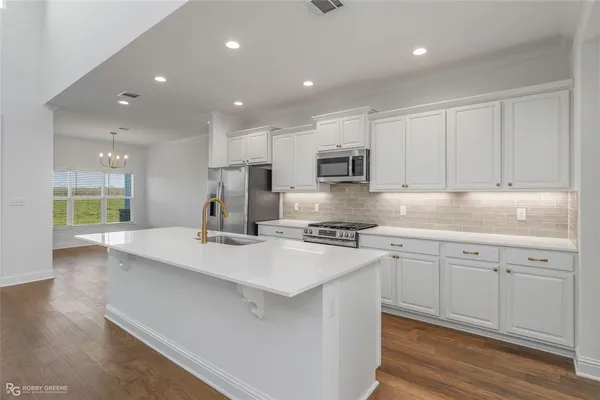 a kitchen with kitchen island white cabinets and appliances