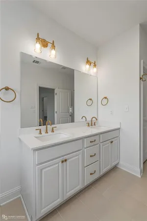 a spacious bathroom with a double vanity sink and a mirror
