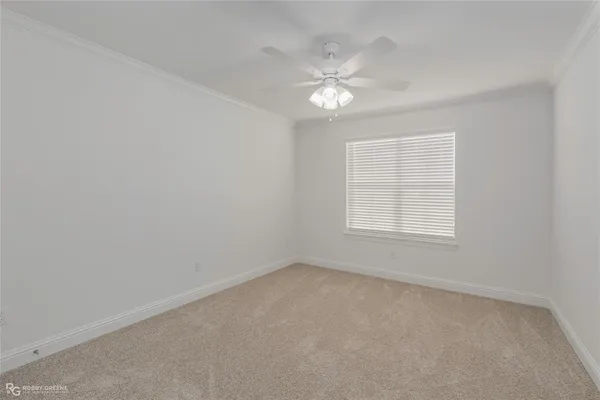 an empty room with windows and chandelier fan