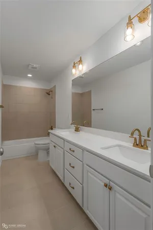 a spacious bathroom with a granite countertop sink a toilet and a mirror