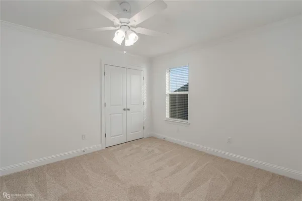 an empty room with windows and fan