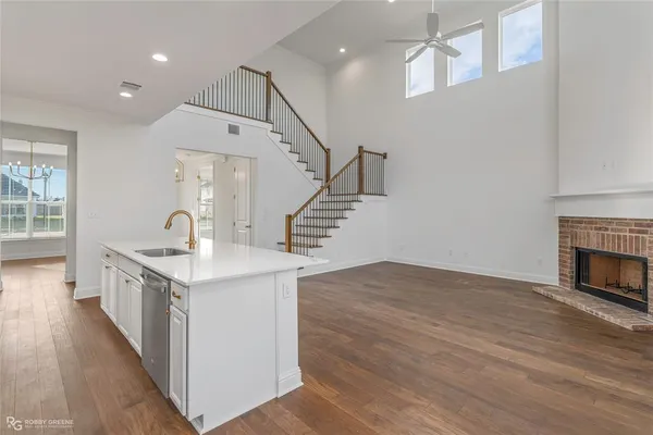 a kitchen with granite countertop a sink and a stove with wooden floor
