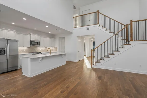 a view of kitchen with wooden floor and electronic appliances