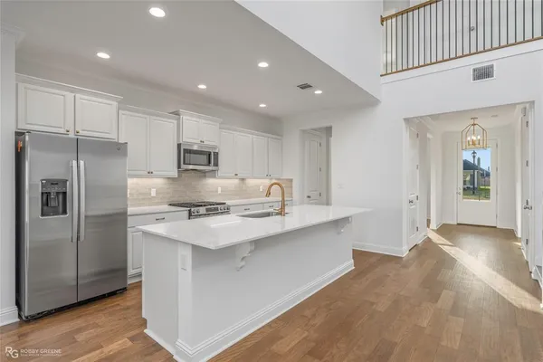 a kitchen with kitchen island a sink stainless steel appliances and cabinets