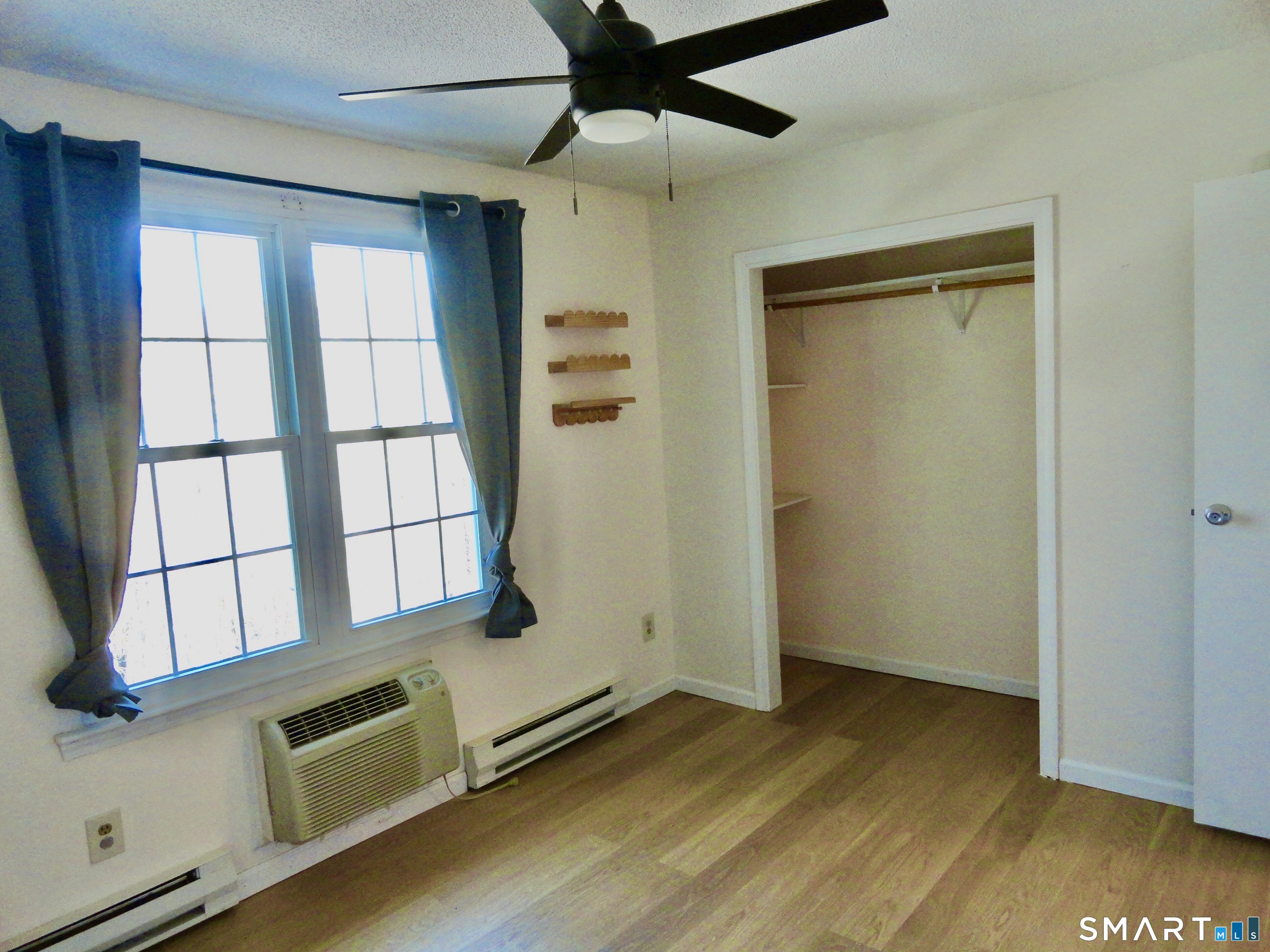 79 Hunter Court, Unit 79 Torrington, CT 06790 - Photo 14 of 19 a view of an empty room with a window and wooden floor
